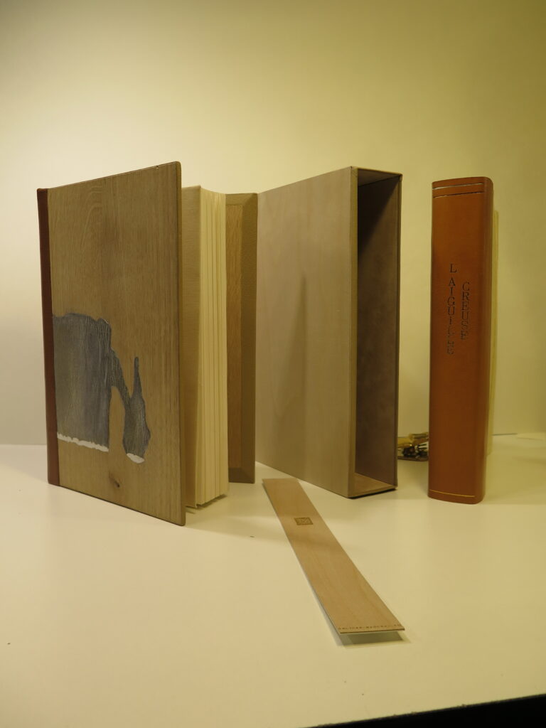 une reliure d'art sur ais de bois, dos en peau, avec étui et chemise